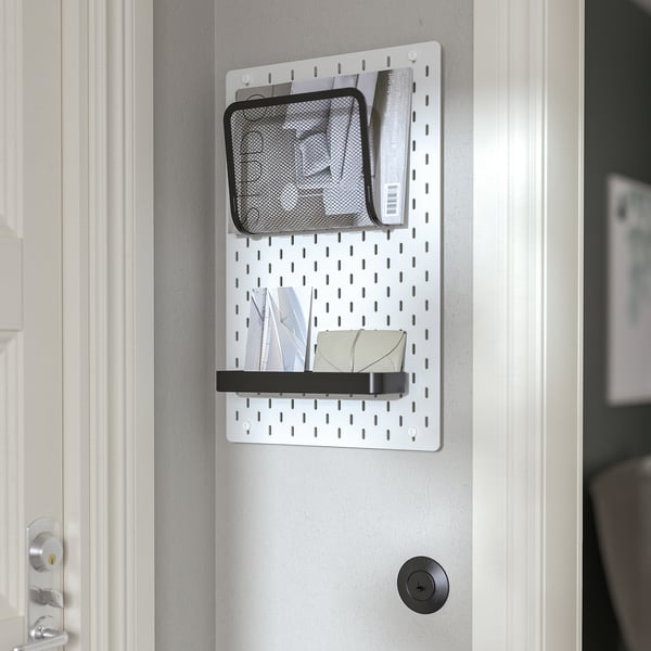 Este un sistem SKÅDIS cu buzunare din plasă și un raft, montat pe o ușă pentru acces ușor la obiecte mici.