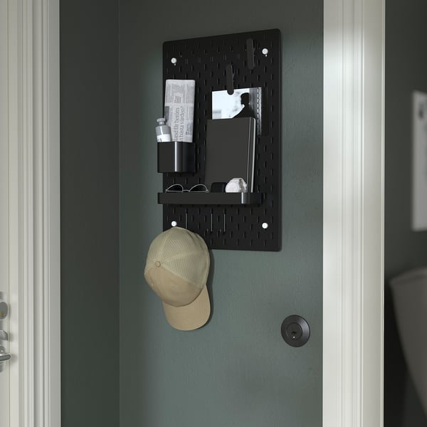 Organizator de perete cu pegboard negru cu accesorii: capac, note, recipiente și pahare.