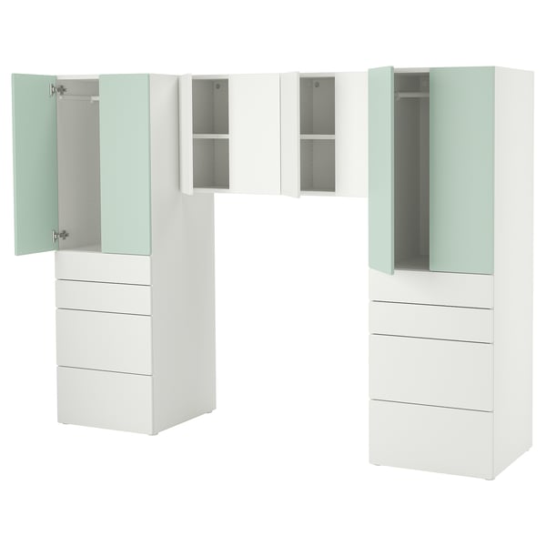 Unitate de depozitare albă modernă pentru copii, cu mai multe sertare și dulapuri de diferite dimensiuni, inclusiv un dulap. Accentele de verde deschis adaugă o notă jucăușă.