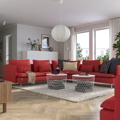 Living modern cu canapea secțională roșie SÖDERHAMN, covor ușor și măsuță de cafea albă.