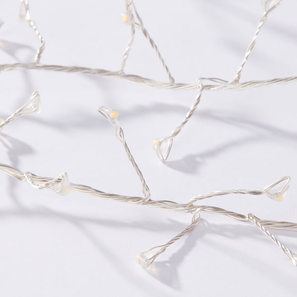 Lumini albe delicate, nenumărate becuri sclipind ușor, aranjate elegant pe o suprafață albă imaculată.