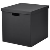 O cutie TJENA în negru. Are formă pătrată, cu capac și mânere, fabricat din carton reciclat.