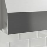 Hota de bucătărie din oțel inoxidabil, design elegant, montată deasupra plăcilor albe.