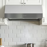 Bucătărie modernă cu hotă din oțel inoxidabil, cu lumini LED și panou de control, montată sub dulapuri albe cu spătar din gresie de metrou.