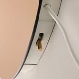 Aplică de perete modernă elegantă cu suport pentru bec auriu fixată pe un cadru alb elegant.