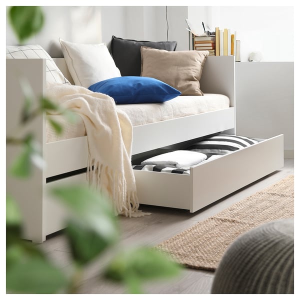 Pat de zi alb modern cu sertare, lenjerie de pat elegantă, perne confortabile și o pătură confortabilă, perfectă pentru dormit sau relaxare.