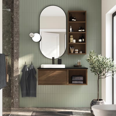 Modern bathroom with ÄNGSJÖN vanity, mirror, sink, and green tiles. Plant on right.