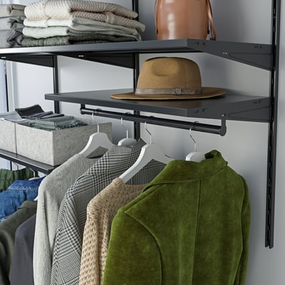 Organised closet with hangers, a hat, and sweaters; dark shelves, neatly arranged clothes.