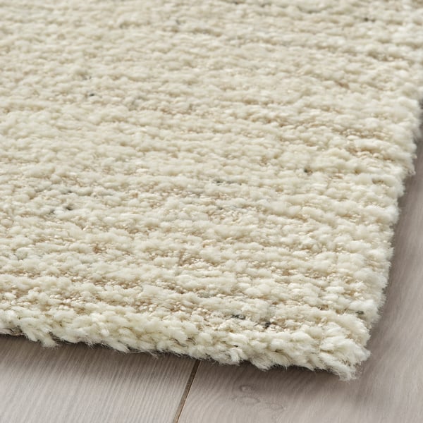 Soft, plush rug with thick pile, neutral tones, durability, and stain resistance.