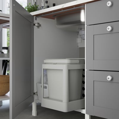 Kitchen cabinet with integrated sink and waste sorting, grey, partially open.