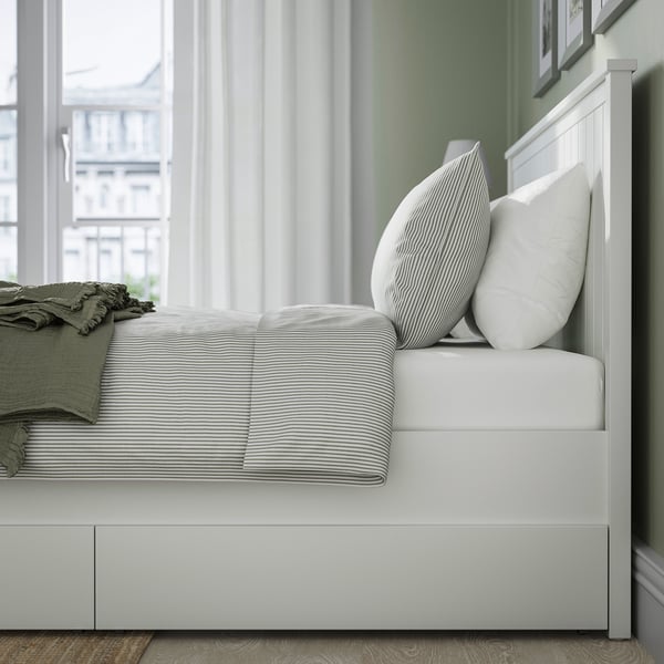Bed with two large drawers on castors for extra storage. Sturdy design and tapered solid wood legs.