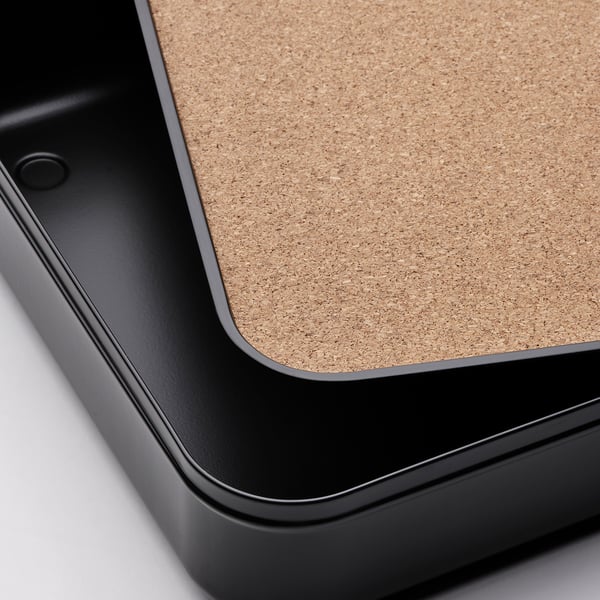 Close-up of a sleek, black desk organiser with a natural cork lid, showcasing high-quality materials and precise craftsmanship.