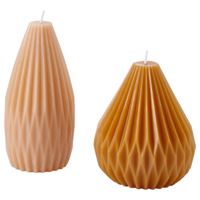 Two HÖSTAGILLE candles, peach and orange, teardrop shaped, textured design, stand on white background.