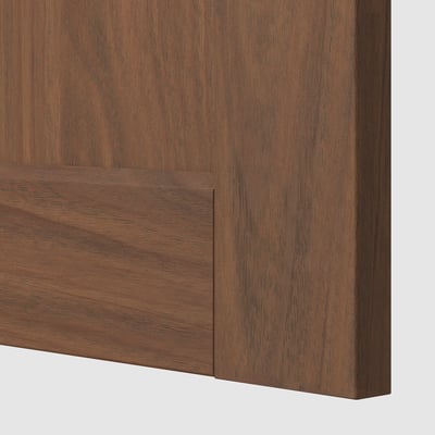 Close-up of walnut-finished kitchen cabinet, showing smooth, sturdy wood texture and edge detail.