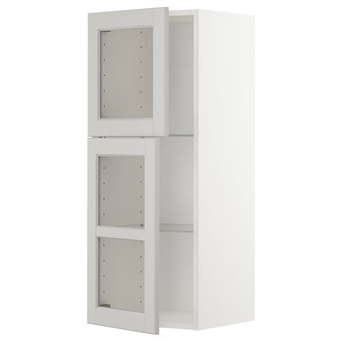A white METOD kitchen cabinet with glass shelves and three empty compartments.