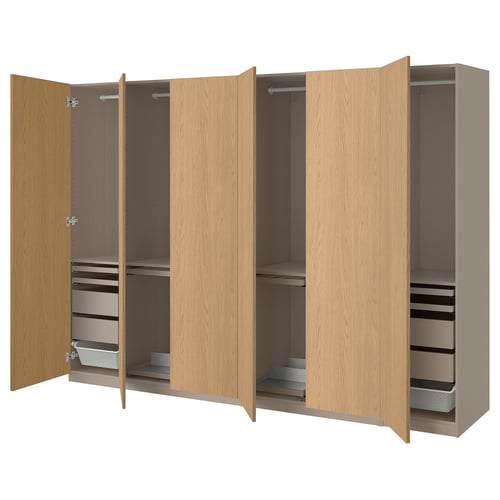 Wooden PAX wardrobe, light brown, modular design with open doors revealing adjustable shelves, drawers, and hanging space.