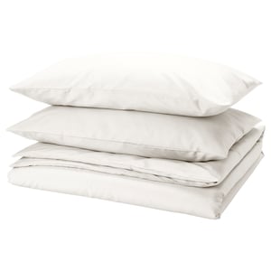 A stack of three white bed linens: two pillows and a duvet from PILTANDVINGE, made from recycled polyester and viscose, smooth and wrinkle-free.