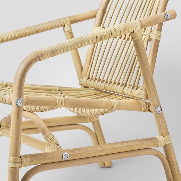 Woven rattan armchair, handcrafted, shown from side highlighting natural, durable material and comfortable, curved design.