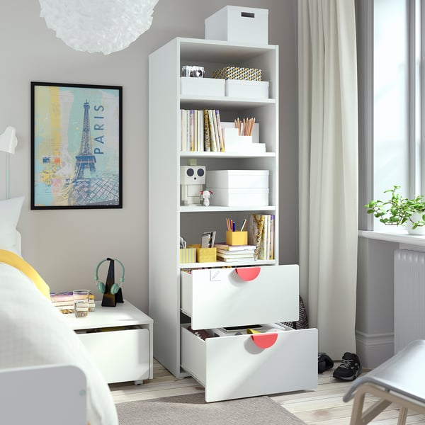 A kids bedroom with SMÅSTAD bookcase showing storage drawers and shelves filled with books and toys.