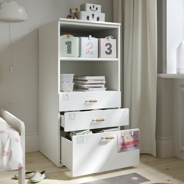 White SMÅSTAD bookcase with storage for kids toys, books, and clothes in a nursery.