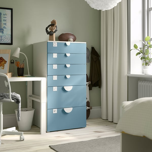 Blue 5-drawer SMÅSTAD chest in bedroom, between desk and window, holding small decor items.