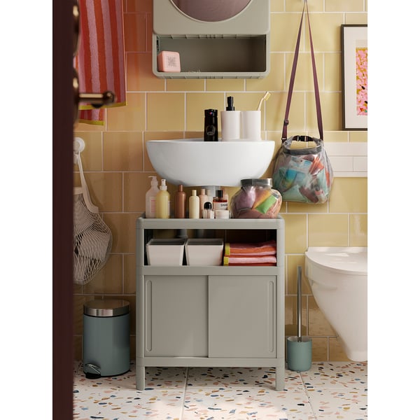 Modern bathroom: white sink, purple bag, patterned floor
