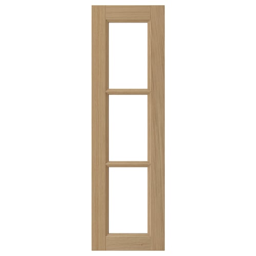 A VEDHAMN oak kitchen cabinet door with a natural wood frame and glass panels. Rectangular, solid oak edges, and a flat design.