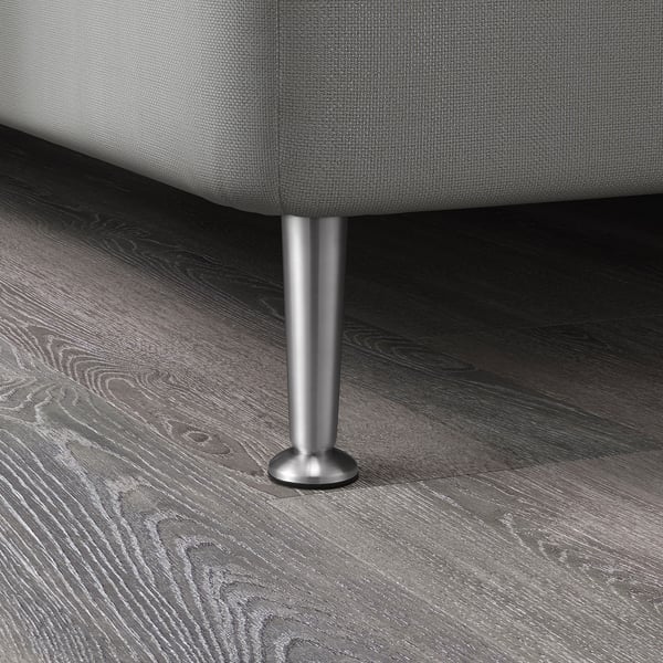 A close-up of a stainless steel furniture leg on a dark wooden floor.