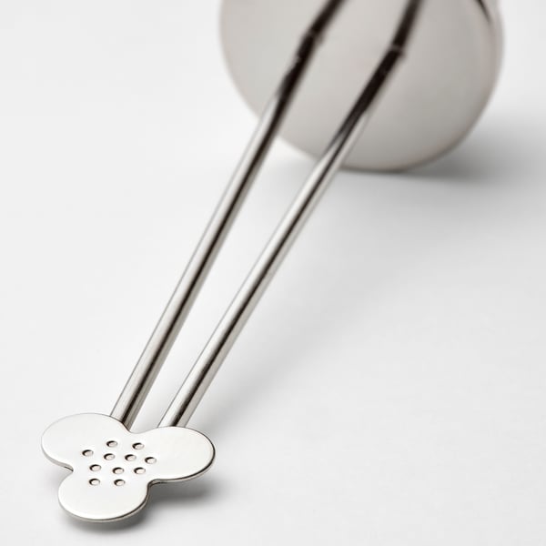 Stainless steel tea infuser with perforated flower shape; sleek, polished handles and simple design.