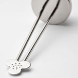 Stainless steel tea infuser with perforated flower shape; sleek, polished handles and simple design.