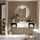 Modern bathroom with floating washstand, sink, mirror, towels, plants, and freestanding bathtub.