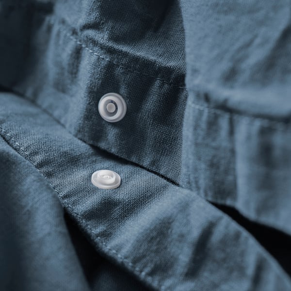 Close-up of light blue duvet cover featuring button closure, showcasing its soft, natural cotton material.
