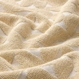 Light beige towel with intricate jacquard pattern; soft, comfy texture.