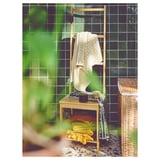 Beige ÄNGSNEJLIKA towel on wooden rack, jacquard pattern, colorful towels below.