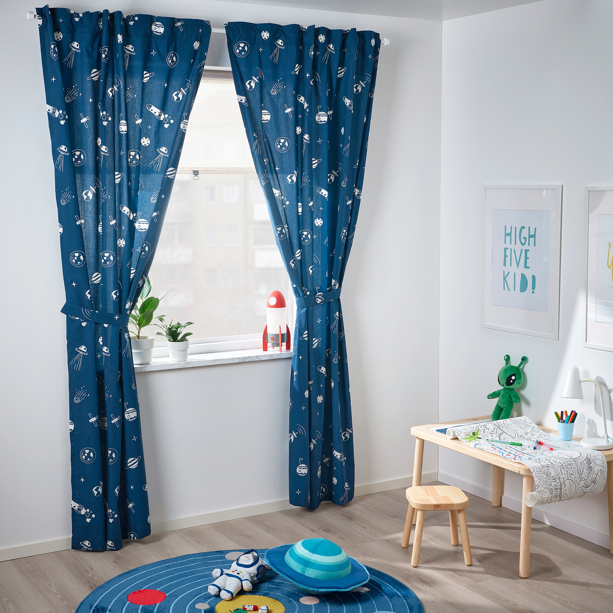 Childs space-themed room with navy AFTONSPARV curtains, toy rocket, alien, and rug.