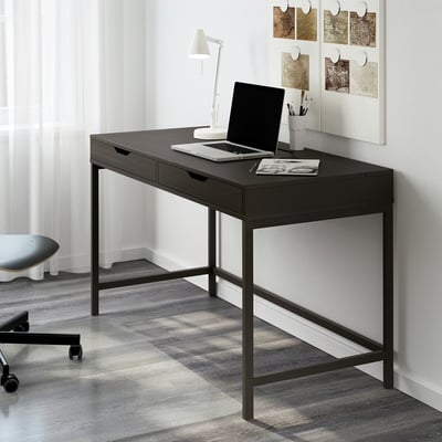 Black ALEX desk, minimalist, sleek surface, built-in drawers, metal frame, against wall, smaller than window and chair.