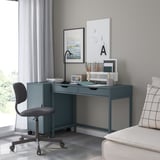 Modern home office with blue ALEX desk, gray chair, and minimalist decor.