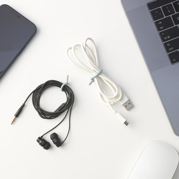 Desk with devices: grey laptop, black smartphone, ALFORSIT white & black cable ties, and a white mouse.