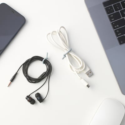 Desk with devices: grey laptop, black smartphone, ALFORSIT white & black cable ties, and a white mouse.