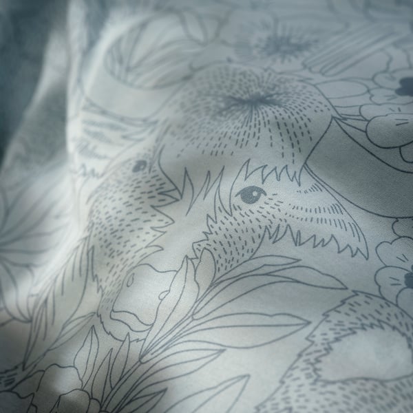Printed cotton fabric with intricate blue floral pattern, showcasing detailed designs and craftsmanship.