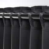 Black curtains with top tabs for hanging, showing how they attach to curtain rod for easy installation and light blocking.