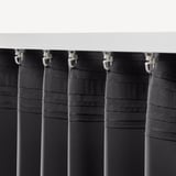 Black curtains with clips hang, blocking light, ensuring privacy.