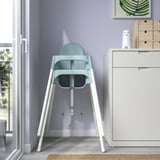 Teal ANTILOP high chair by window, portable & safe for kids up to 3yrs or 15kg, with safety belt.