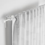 Curtains with geometric pattern, partially drawn, filtering light.
