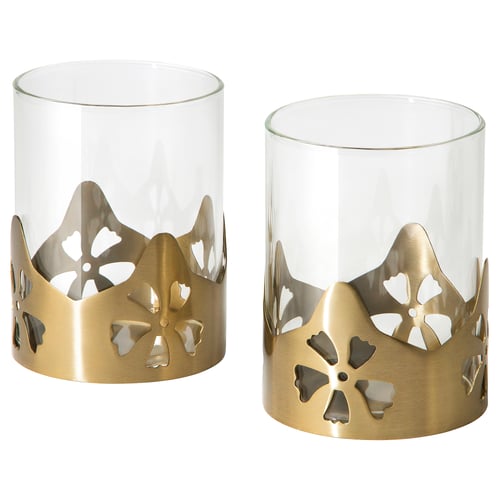 Golden metal and glass tealight holders with intricate cut-out flower designs, exuding a warm, welcoming ambiance.