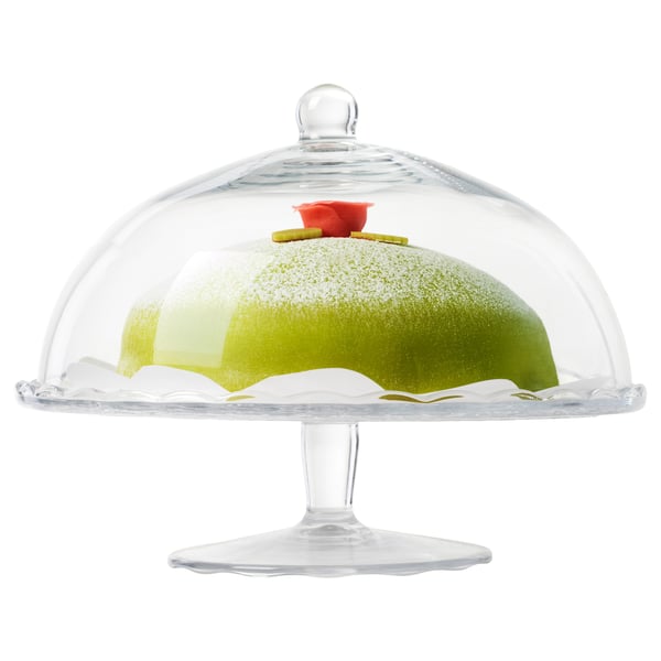 Clear glass cake stand with dome lid displays green cake, keeps contents fresh and protected.