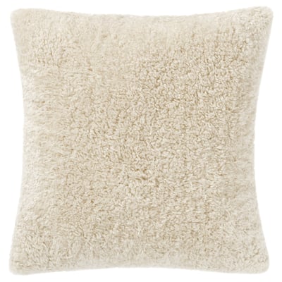 This image shows a square-shaped cream-colored cushion cover named ÅSJORDFLY made from soft, eco-friendly teddy fur.
