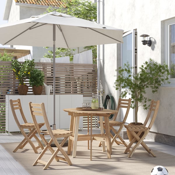 Outdoor dining set: ASKHOLMEN in natural wood with 4 folding chairs, round table, and beige umbrella. Perfect for small outdoor spaces.