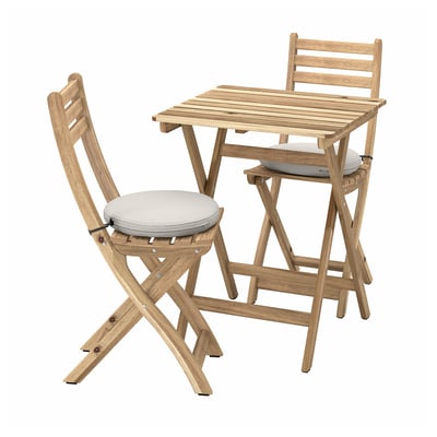Wooden outdoor dining set with light cushions, perfect for small spaces.