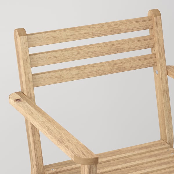 Natural-colored wooden chair with vertical slatted back and armrests, made from solid acacia wood.
